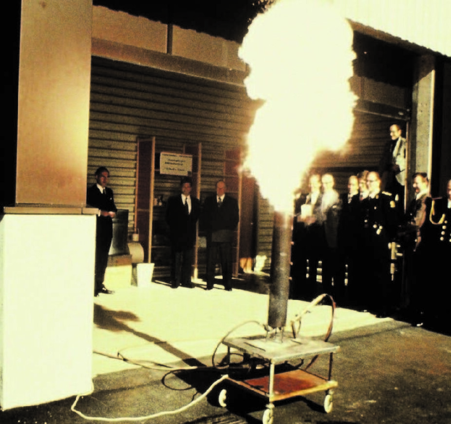 Rolf demonstrerer støveksplosjoner for Hans Majestet Kong Olav V under åpningen av nybygget til CMI på Fantoft i juni 1978.