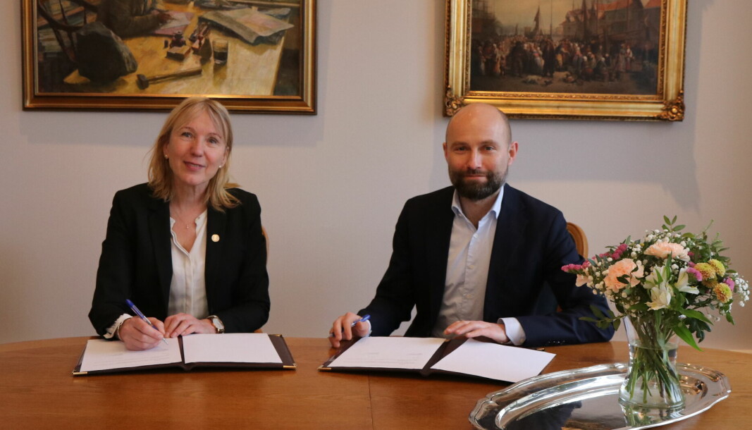 Margareth Hagen og Jostein Kobbeltvedt signerer samarbeidsavtale mellom UiB og Raftostiftelsen.