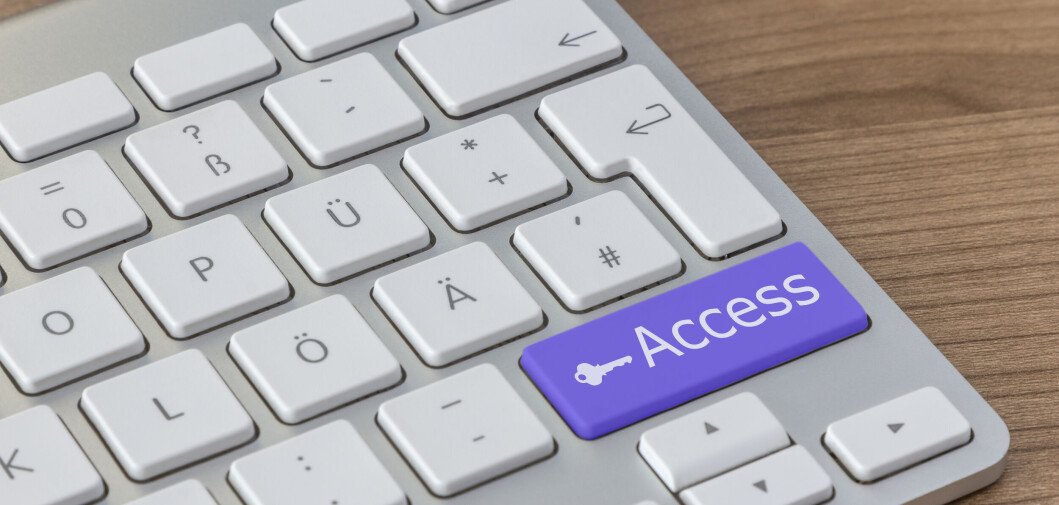 Access and key icon on a large blue button of a modern keyboard on a wooden desktop Access and key icon on a large blue button of a modern keyboard on a wooden desktop