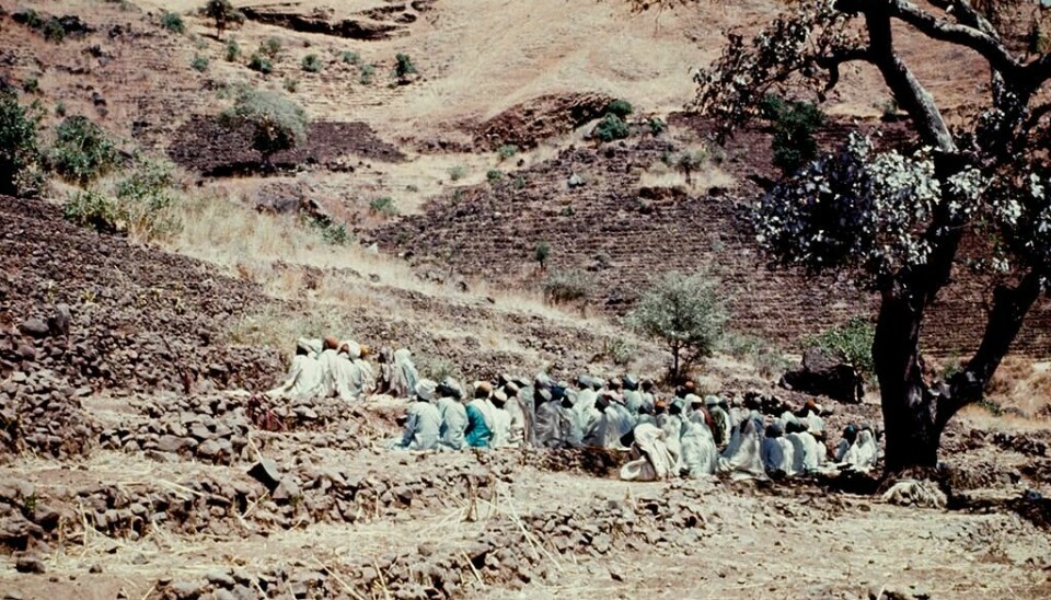 En gruppe menn er samlet ved et fjell for å be.