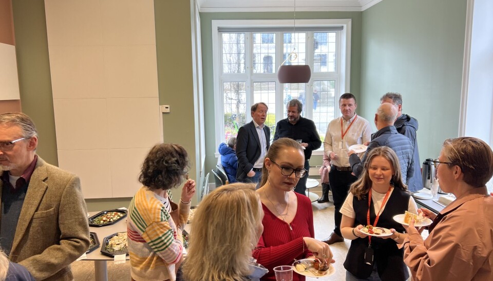 Folk spiser kake og prater sammen under åpningen av Lektorsenteret.