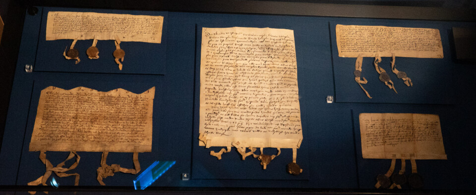 Diplomer i en utstillingsmonter på Bryggens museum.