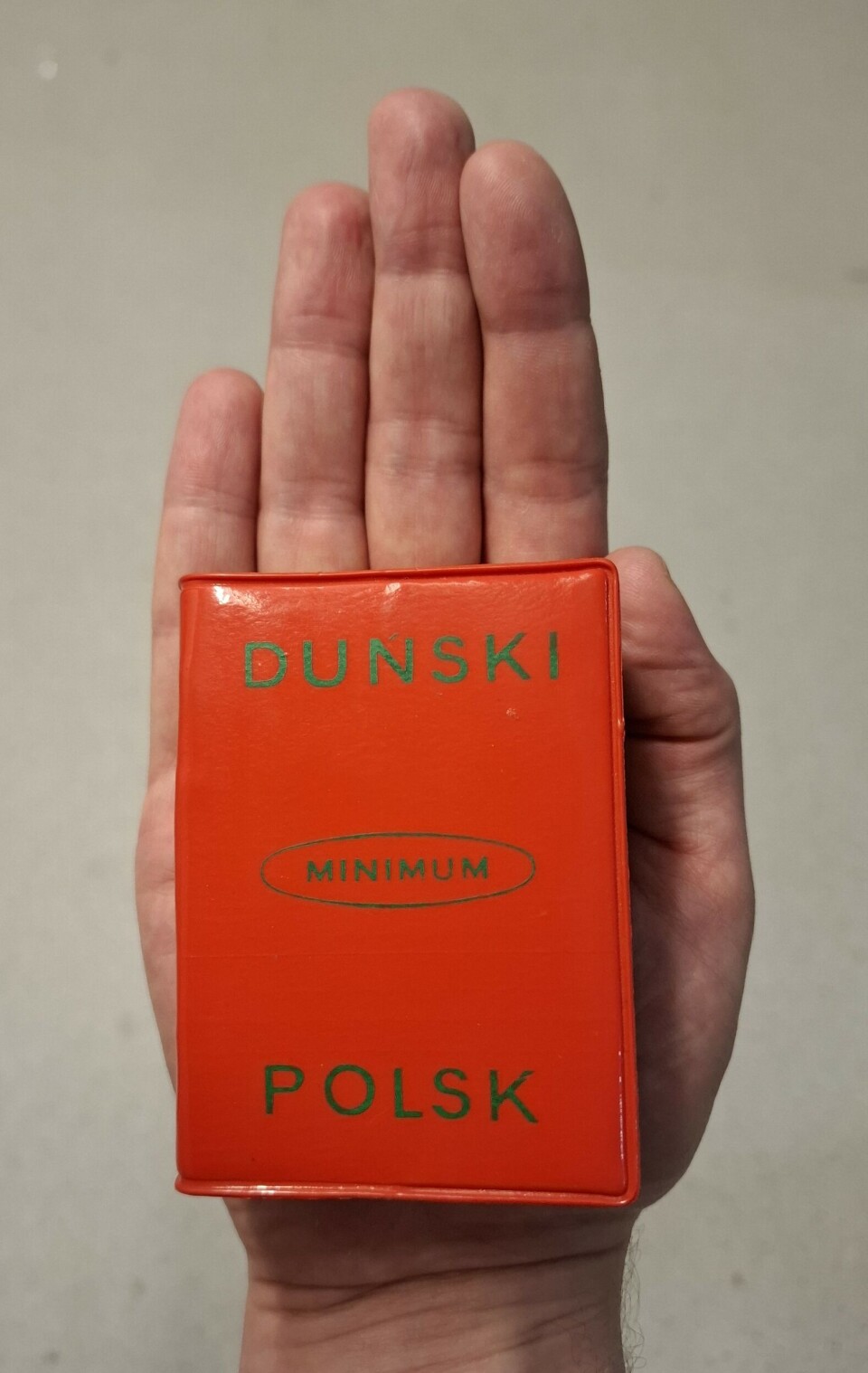 En dansk-polsk ordbok fra Språksamlingene som er liten nok til å romme håndflaten til et voksent menneske.